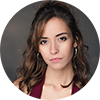 Carmen Lorenzo has long, dark brown hair and is wearing gold hoop earrings
