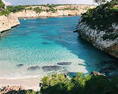 Turquoise blue waters with white wave caps smoothly guiding along the cliffs and ending at shore